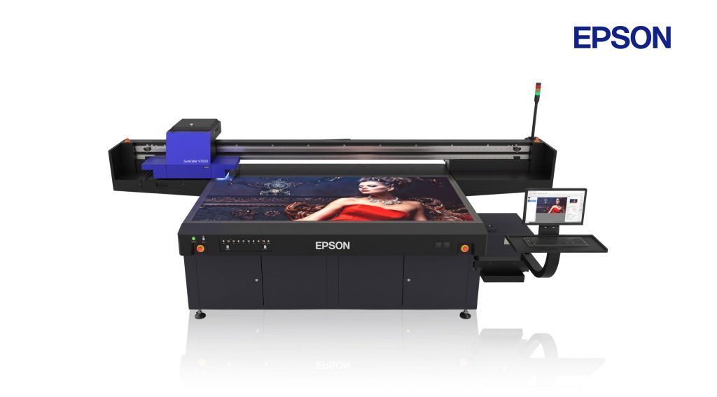 Mesin printer UV Epson V7000 flatbed industri dalam proses mencetak media rigid.